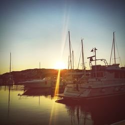 Sailboats in sea at sunset