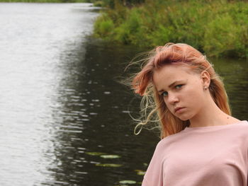 Portrait of woman standing by lake