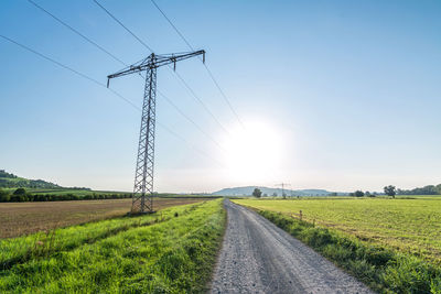 Road amidst field against sky