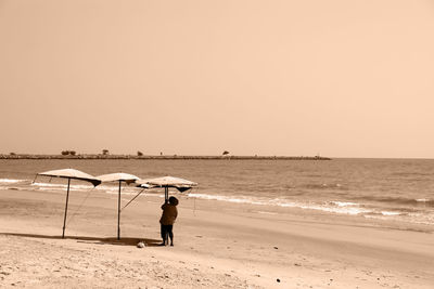 Full length of man on beach against clear sky