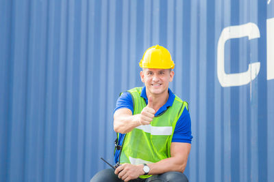 Happy man working against clear blue sky