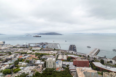 High angle view of townscape by sea against sky