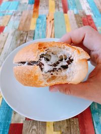 Close-up of hand holding bread on table