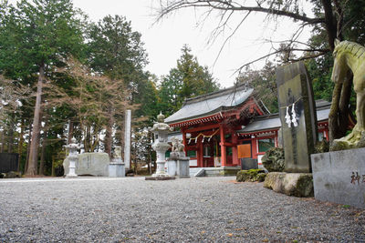 Traditional building by trees against sky