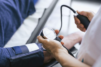 Close-up of doctor checking patient pulse at hospital