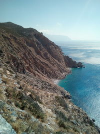 Mountain by sea against sky