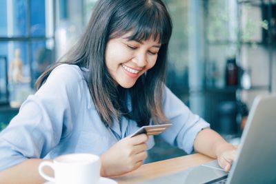 Young woman using mobile phone in cafe