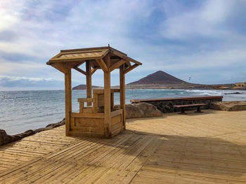 Pier on beach against sky