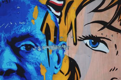 Close-up of multi colored graffiti on blue wall