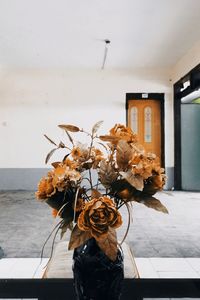 Close-up of wilted flower vase against wall