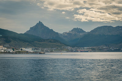 Scenic view of sea by mountains against sky