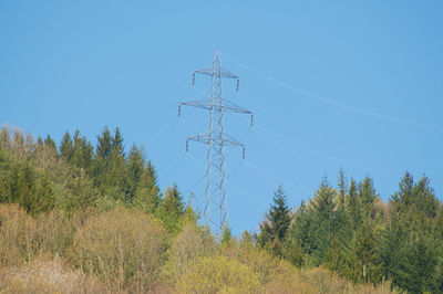 Low angle view of electricity pylon against clear sky