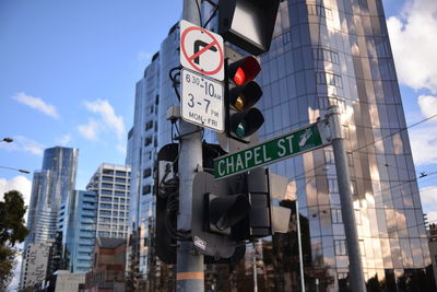 Low angle view of road signs against buildings in city