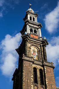 Low angle view of clock tower against cloudy sky