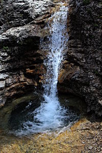 Scenic view of waterfall against sky