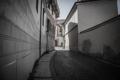Empty alley amidst buildings in city