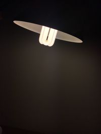 Low angle view of illuminated lamp against black background