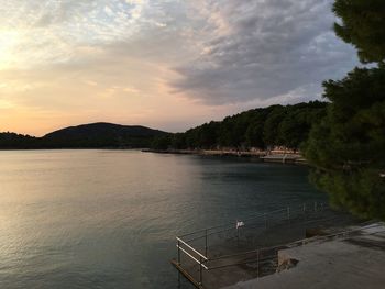 Scenic view of river against sky at sunset