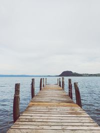 Wooden pier over sea against sky