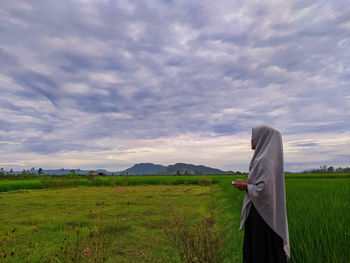 Man standing on field against sky