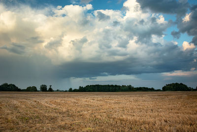 Cloud with rain over stubble field