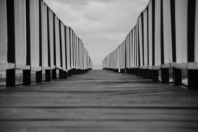 Surface level of narrow walkway against the sky