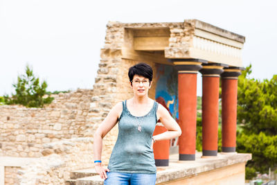 Portrait of woman standing against brick wall