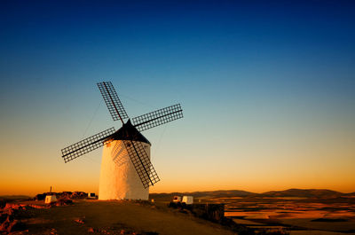 Traditional windmill against clear sky during sunset