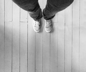 Low section of man standing on hardwood floor