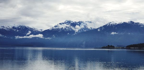 Scenic view of lake and snowcapped mountains against sky