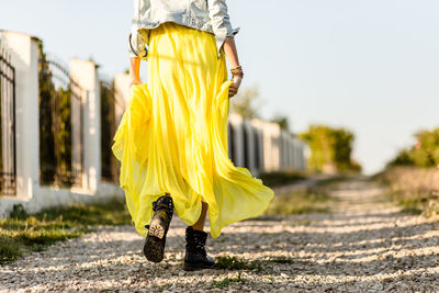 Low section of woman standing on road