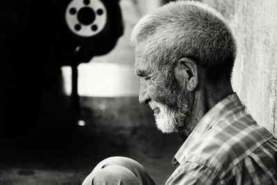 Side view of man looking at camera