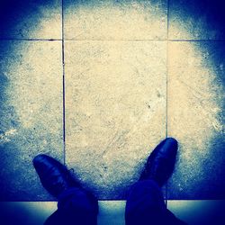 Low section of woman standing on tiled floor