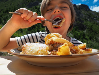 Boy eating dessert from plate