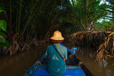 Rear view of man wearing hat against trees