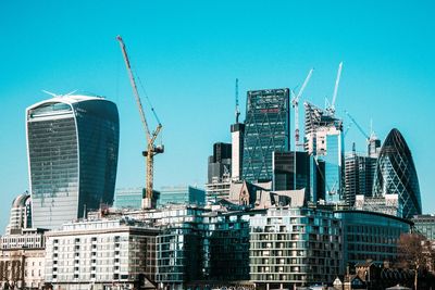 Modern buildings in city against clear blue sky