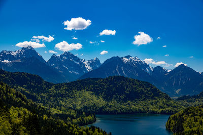 Scenic view of lake and mountains against blue sky