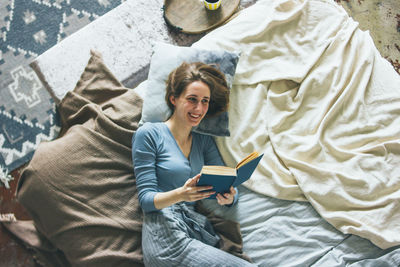 Woman holding a while sitting on bed