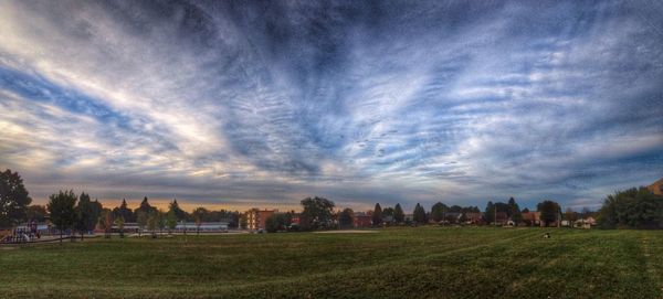 Scenic view of grassy field against cloudy sky