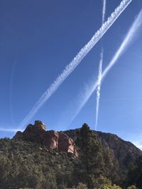 Low angle view of vapor trail against blue sky