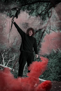 Man standing by tree trunk