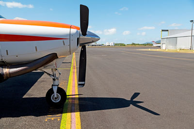 Airplane on airport runway against sky