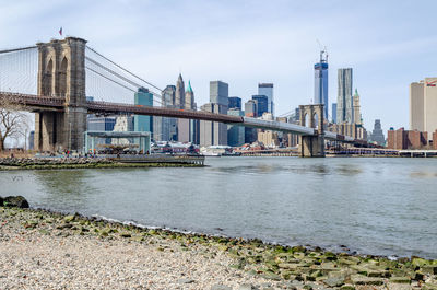 View of bridge over river in city against sky