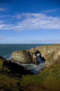 Rocks by sea against sky