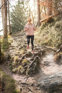 Woman standing by stream in forest