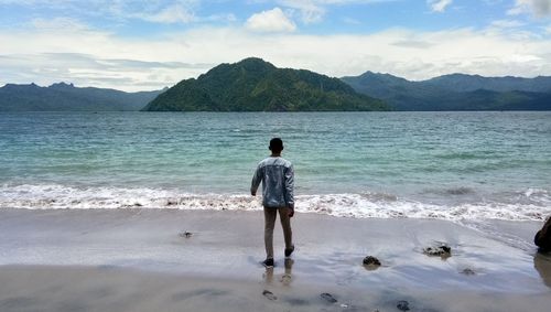 Rear view of man walking at beach