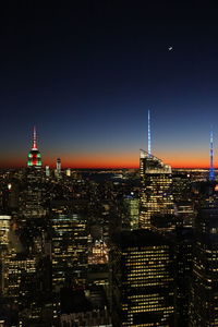 Illuminated buildings in city against sky at night