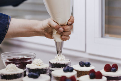 Cropped hands icing cupcake
