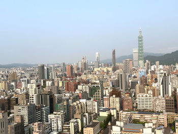 Aerial view of buildings in city against clear sky