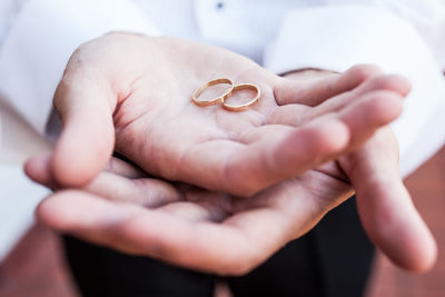 Midsection of priest holding wedding rings